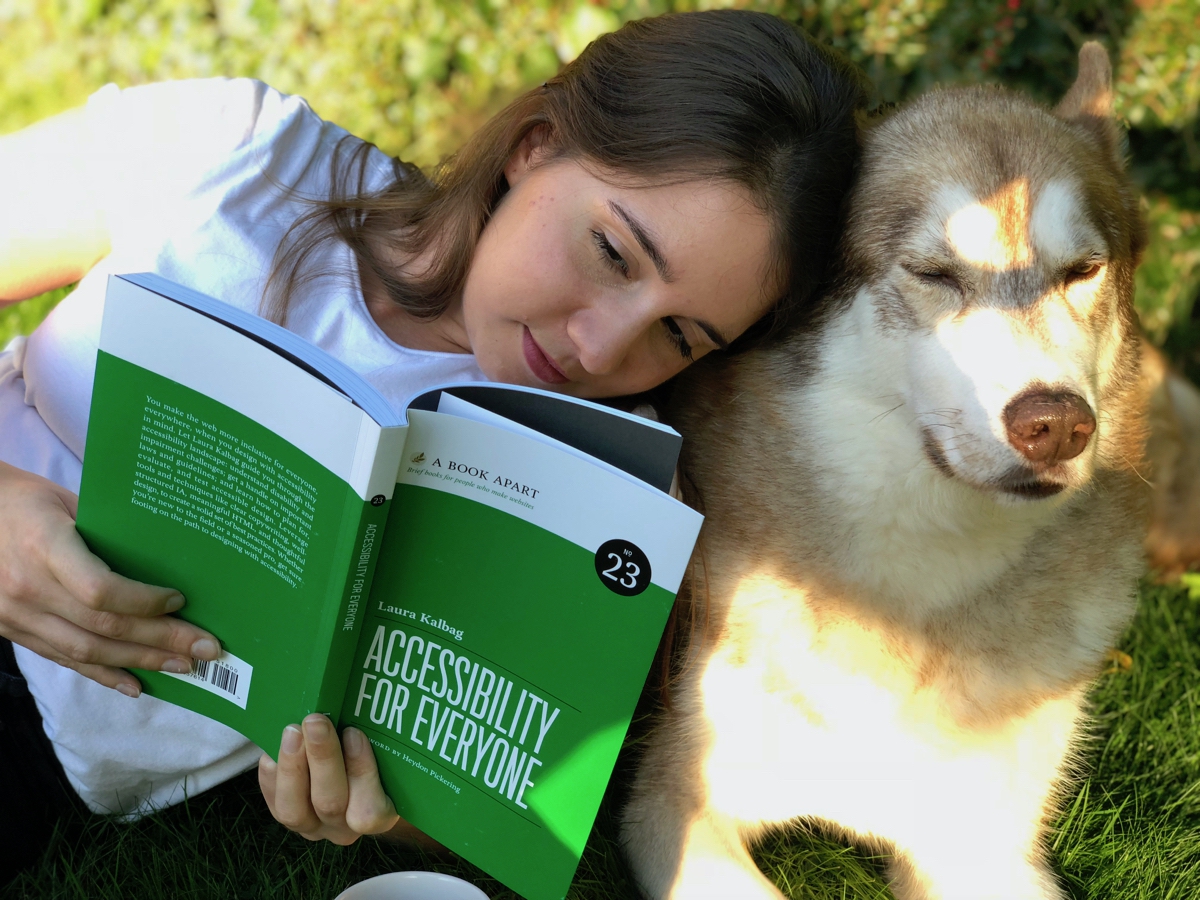 me reading Accessibility For Everyone in the garden next to Oskar the huskamute who couldn’t care less.